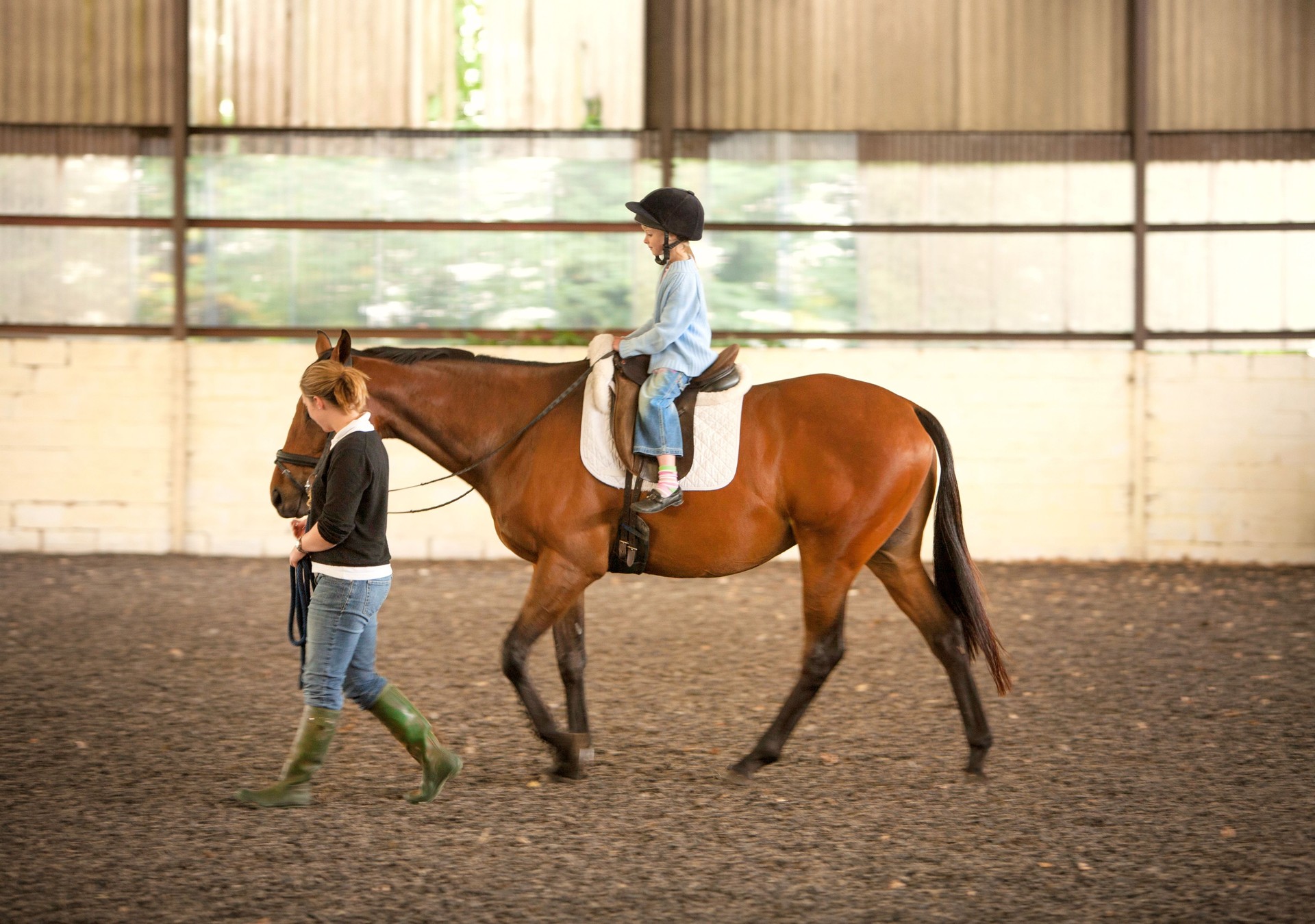 A nervous young girl taking a riding lesson